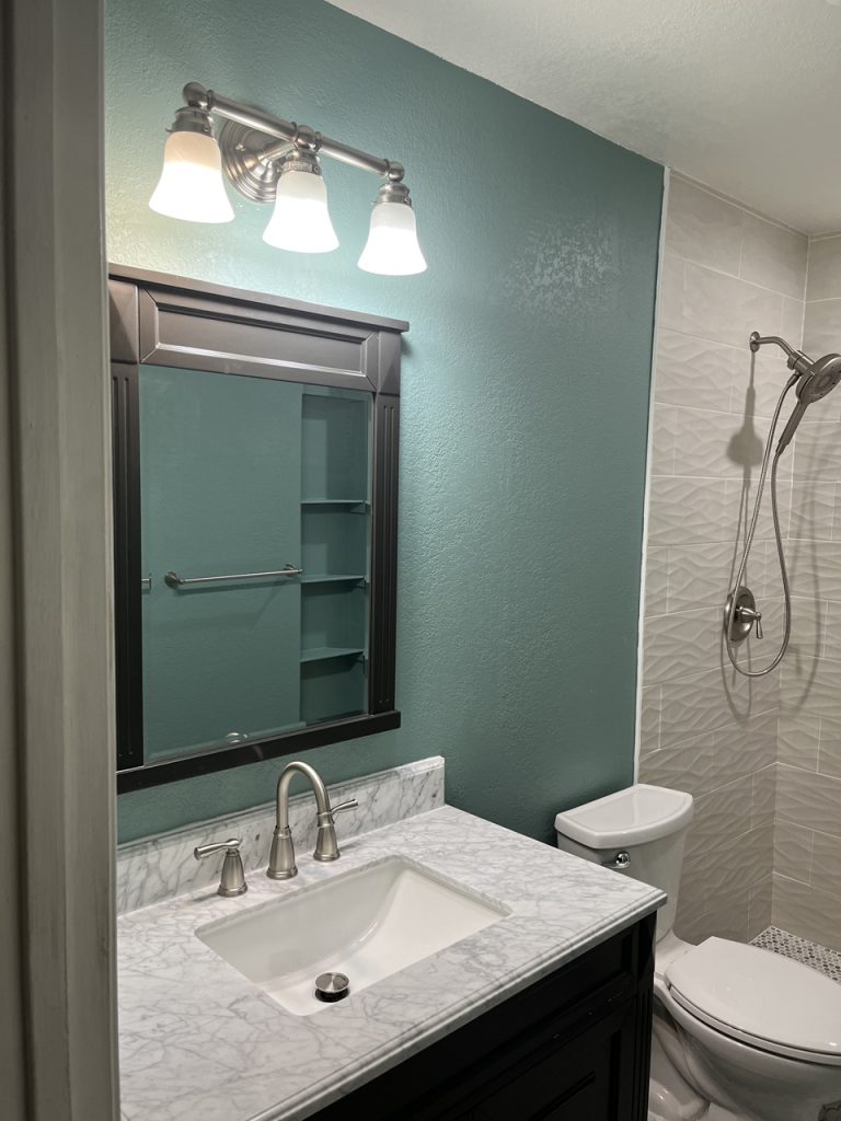 bathroom with green walls, open shower, marble countertop