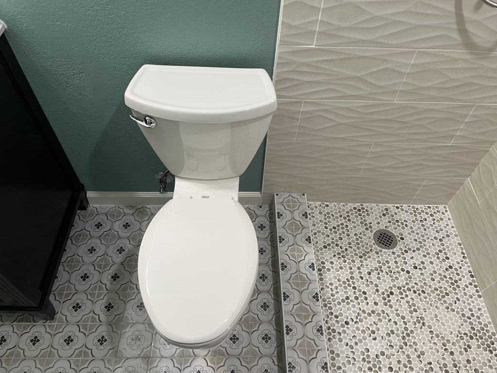 bird's eye view of a bathroom with unique tile flooring and a white toilet