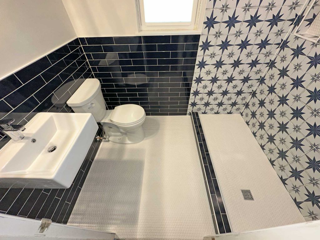 revamped white bathroom with blue and white tiles
